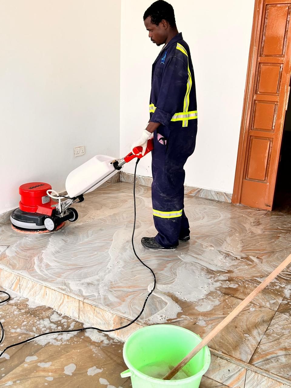 Posh & Allied technician machine-cleaning a floor in Kenya
